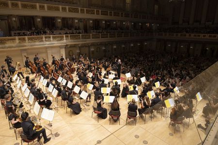 Ansicht auf das Orchester und Dirigent von hinter der Bhne