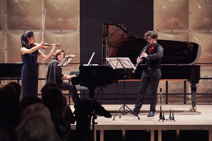Studentin mit Geige, Student mit Klarinette, Frau am Flgel auf einer Bhne