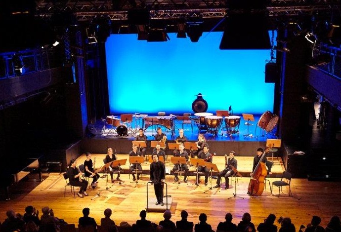 Kammerorchester mit Dirigent auf einer Bhne vor Publikum w?hrend eines Konzertes